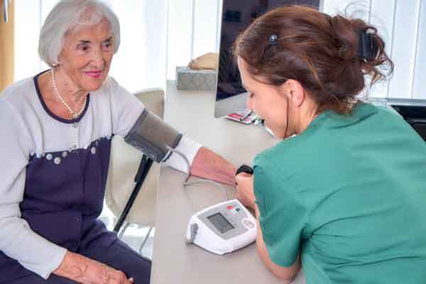Dr Iris Steiner beim Blutdruckmessen einer Seniorin